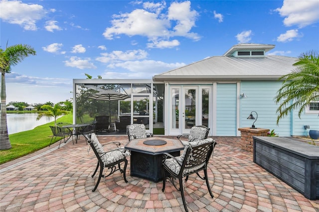 view of patio / terrace with a water view, an outdoor fire pit, and french doors