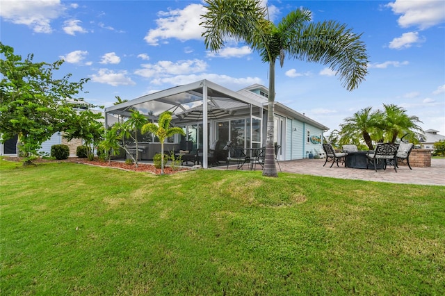 rear view of house with a lanai, a patio, and a lawn