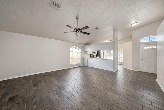 unfurnished living room featuring a textured ceiling, dark hardwood / wood-style floors, and ceiling fan