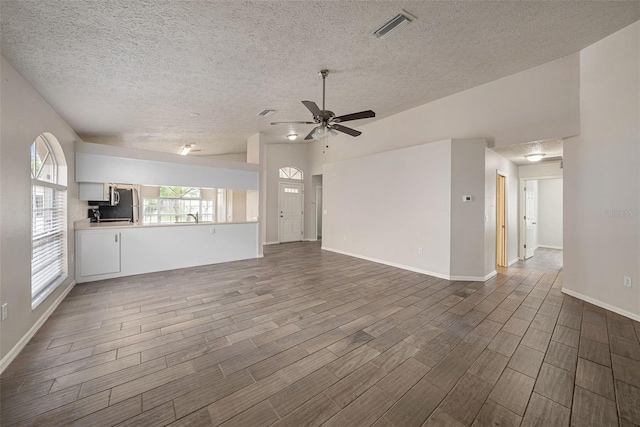 unfurnished living room with a textured ceiling, ceiling fan, and hardwood / wood-style flooring