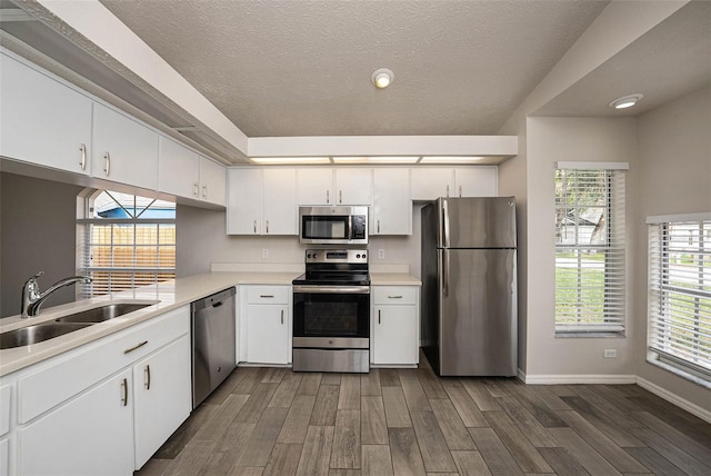 kitchen featuring stainless steel appliances, white cabinetry, and dark wood-type flooring