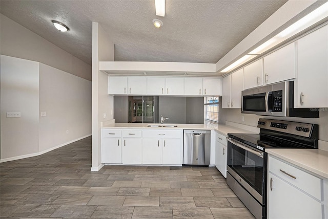 kitchen featuring stainless steel appliances, white cabinets, a textured ceiling, and sink