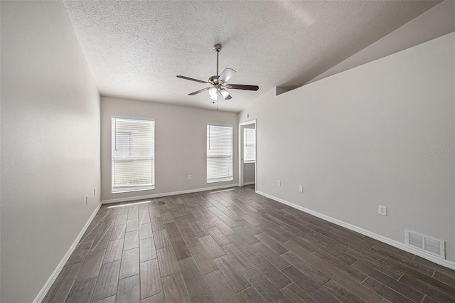 spare room featuring ceiling fan, a textured ceiling, dark hardwood / wood-style floors, and vaulted ceiling