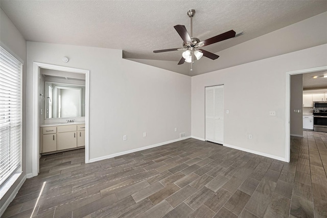 unfurnished bedroom featuring a textured ceiling, vaulted ceiling, dark hardwood / wood-style flooring, and ceiling fan