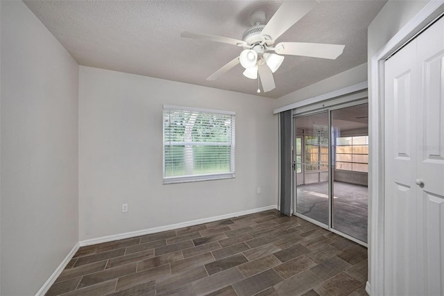 spare room featuring ceiling fan, dark hardwood / wood-style floors, and a wealth of natural light