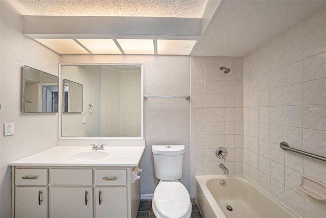 full bathroom with vanity, a textured ceiling, tiled shower / bath, and toilet