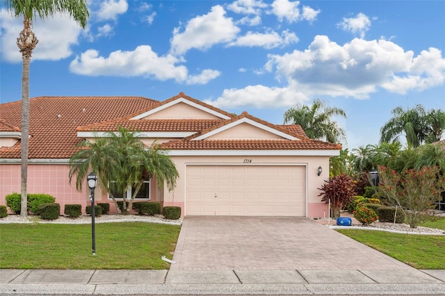 mediterranean / spanish-style home with a garage and a front lawn