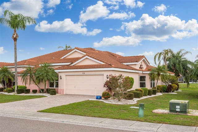 mediterranean / spanish-style home featuring a garage and a front yard