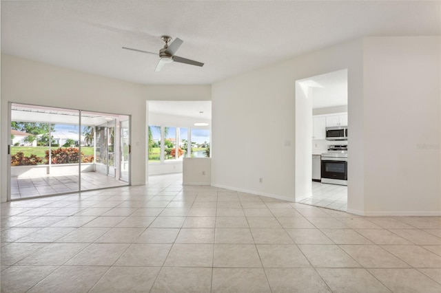 tiled empty room featuring a wealth of natural light and ceiling fan