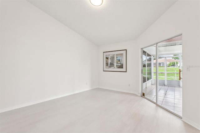 spare room with light wood-type flooring and vaulted ceiling