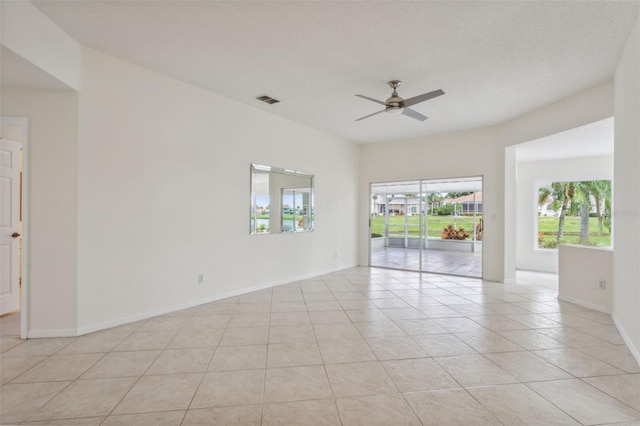 tiled spare room with a textured ceiling and ceiling fan