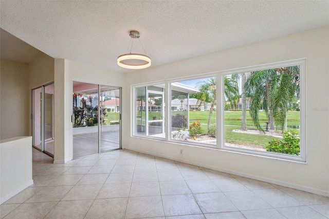 empty room with light tile patterned flooring and a textured ceiling