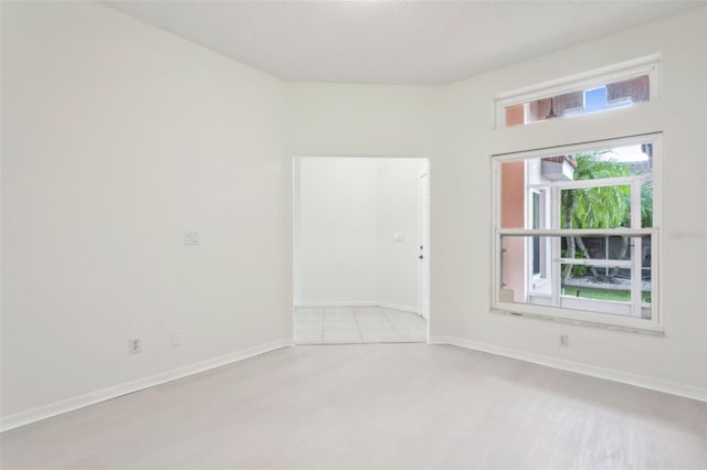 empty room featuring light wood-type flooring and a textured ceiling