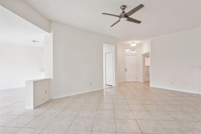 tiled spare room featuring ceiling fan