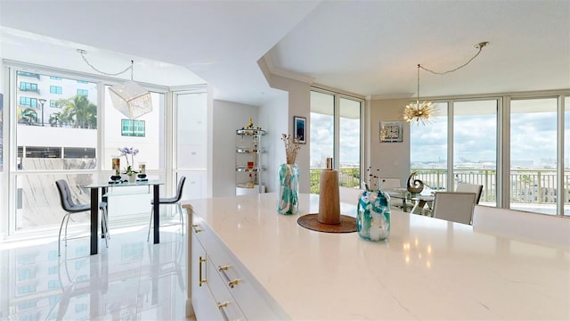 kitchen featuring ornamental molding, white cabinets, plenty of natural light, and pendant lighting