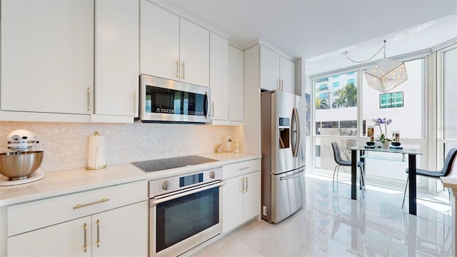 kitchen featuring decorative backsplash, white cabinets, stainless steel appliances, and light tile patterned floors