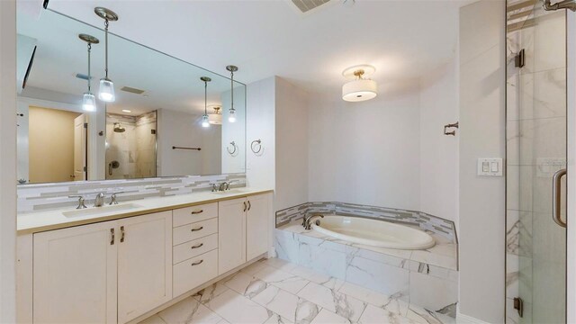 bathroom with vanity and shower with separate bathtub