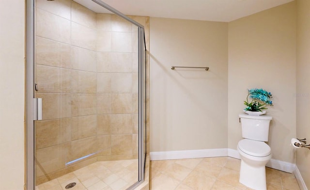 bathroom featuring a shower with door, toilet, and tile patterned floors