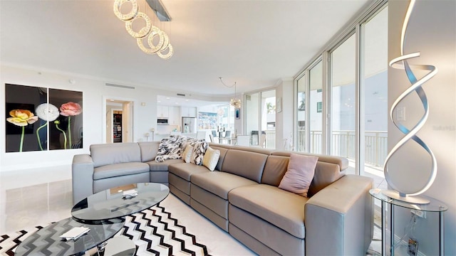 living room featuring ornamental molding, a chandelier, and plenty of natural light