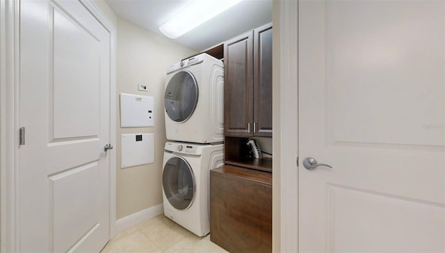 laundry room featuring cabinets and stacked washer and dryer