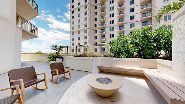 view of patio / terrace featuring an outdoor fire pit and a balcony