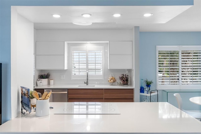 kitchen with white cabinets, dishwasher, cooktop, and sink