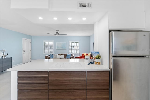 kitchen featuring stainless steel refrigerator, ceiling fan, and electric stovetop