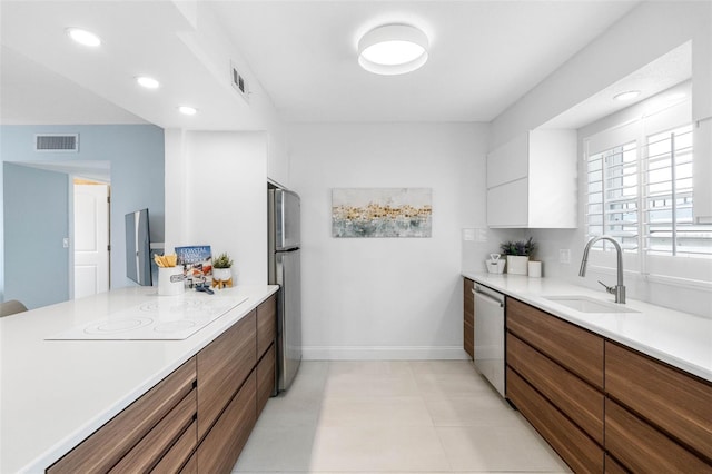 kitchen featuring white cabinetry, sink, and appliances with stainless steel finishes