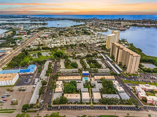 aerial view at dusk featuring a water view