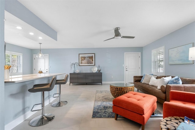 living area featuring light tile patterned floors, ceiling fan, baseboards, and recessed lighting