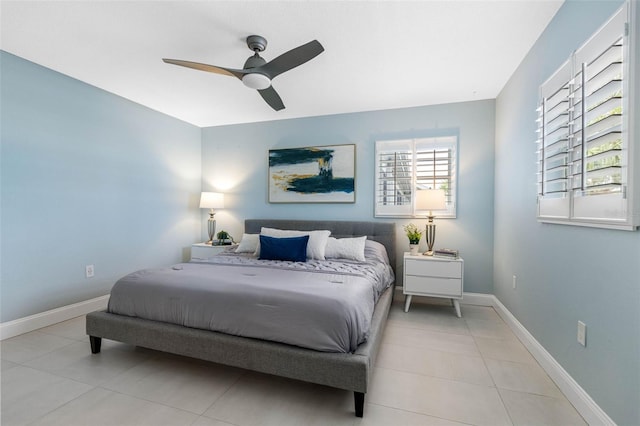 tiled bedroom with baseboards and a ceiling fan