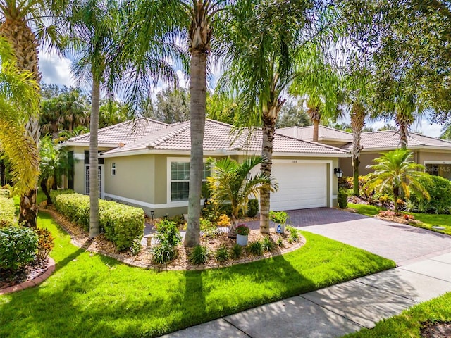 view of front of home with a garage and a front lawn