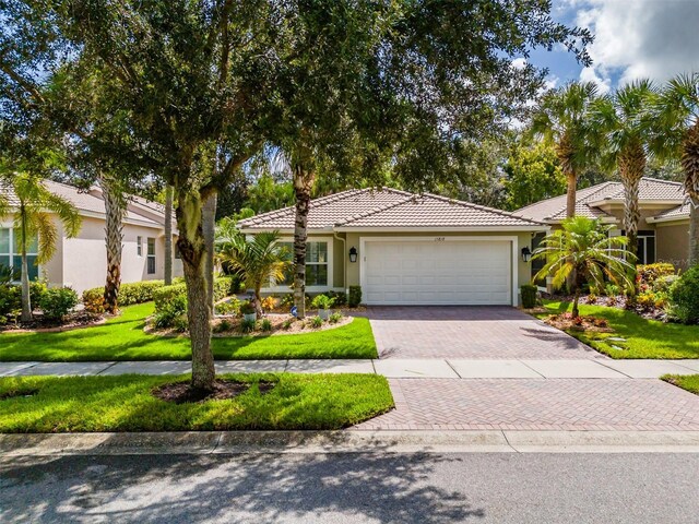 view of front of home with a garage and a front lawn