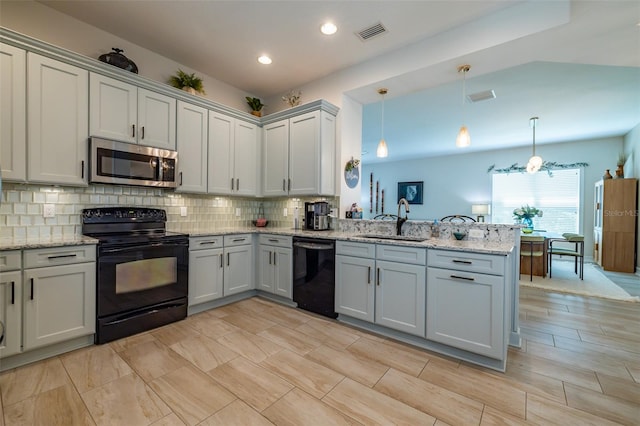 kitchen with hanging light fixtures, backsplash, sink, black appliances, and kitchen peninsula