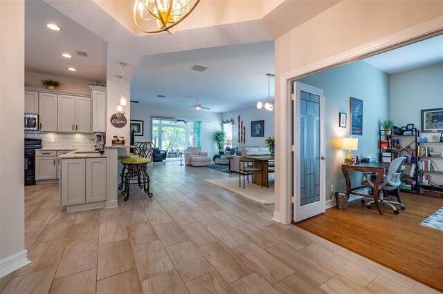 interior space featuring light wood-type flooring, a notable chandelier, and sink