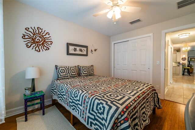 bedroom with ceiling fan, dark hardwood / wood-style floors, and a closet