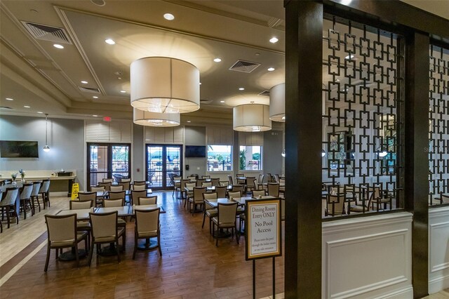 dining space featuring wood-type flooring and ornamental molding