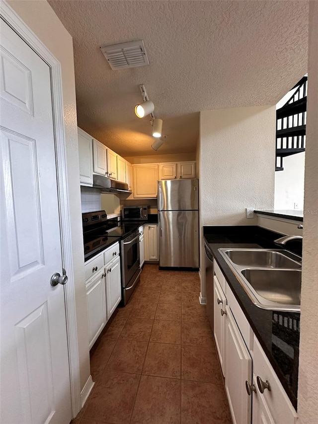 kitchen with a textured ceiling, stainless steel appliances, and sink