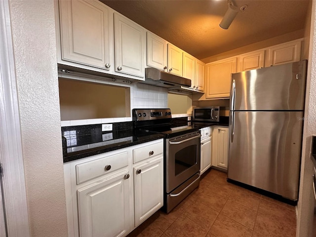 501 Knights Run Ave Unit 1327, Tampa, FL 33602 - kitchen featuring dark countertops, appliances with stainless steel finishes, under cabinet range hood, white cabinetry, and tile patterned floors