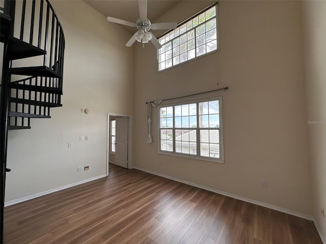 entryway featuring ceiling fan, a towering ceiling, and dark wood-type flooring