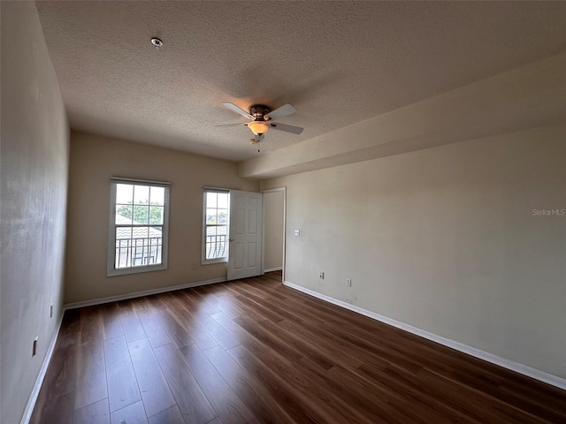 empty room featuring a textured ceiling, dark hardwood / wood-style flooring, and ceiling fan