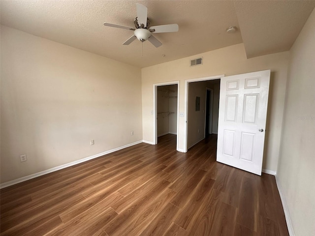 501 Knights Run Ave Unit 1327, Tampa, FL 33602 - unfurnished bedroom featuring a closet, visible vents, a walk in closet, baseboards, and dark wood-style floors