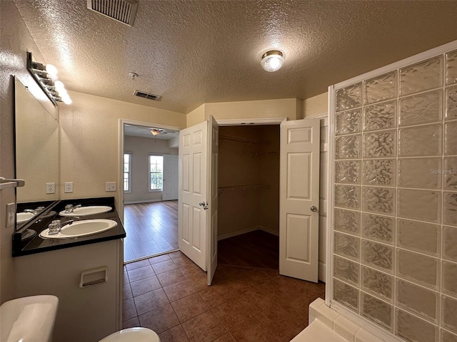 bathroom with vanity, a textured ceiling, and hardwood / wood-style floors