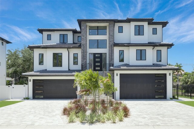 6012 Kipps Colony Dr E, Gulfport, FL 33707 - contemporary house featuring fence, decorative driveway, an attached garage, and stucco siding