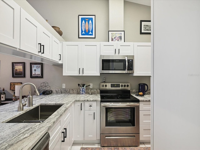 kitchen featuring white cabinets, light stone counters, sink, and appliances with stainless steel finishes