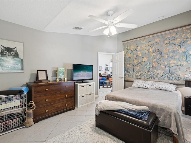 tiled bedroom with a textured ceiling and ceiling fan