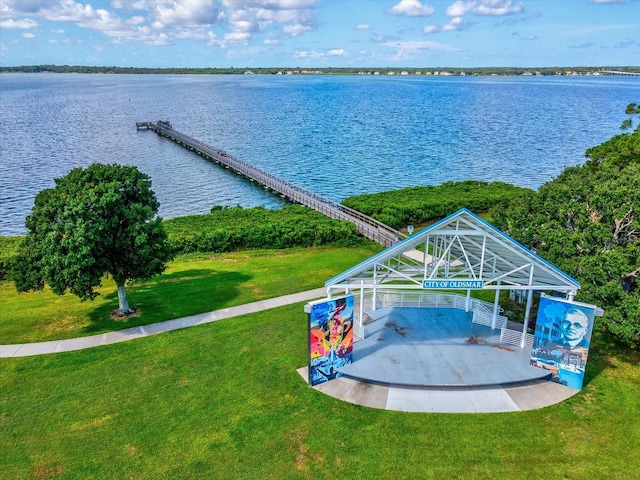 view of dock with a lawn and a water view