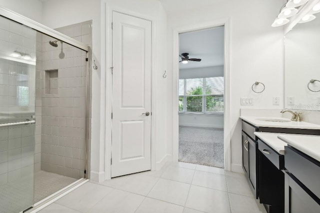 bathroom with ceiling fan, vanity, a shower with shower door, and tile patterned floors