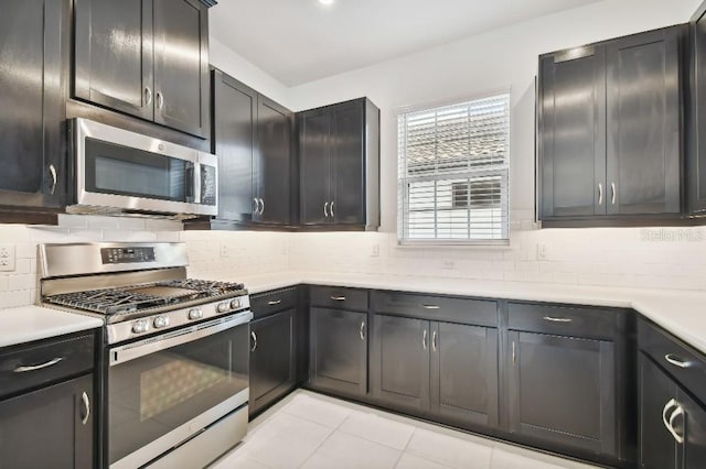 kitchen featuring appliances with stainless steel finishes, decorative backsplash, and light tile patterned flooring