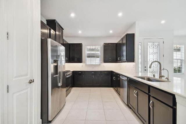 kitchen featuring appliances with stainless steel finishes, decorative backsplash, sink, and light tile patterned floors